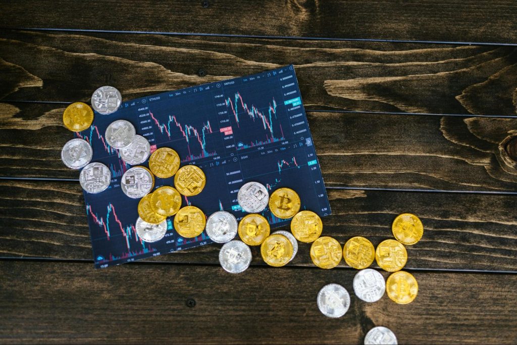 Gold and silver coins laid on top of a photo of a statistical graph.